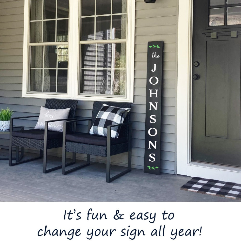 An outdoor chalkboard welcome sign next to front door crafted into a custom last name sign using letter stencils and paint markers