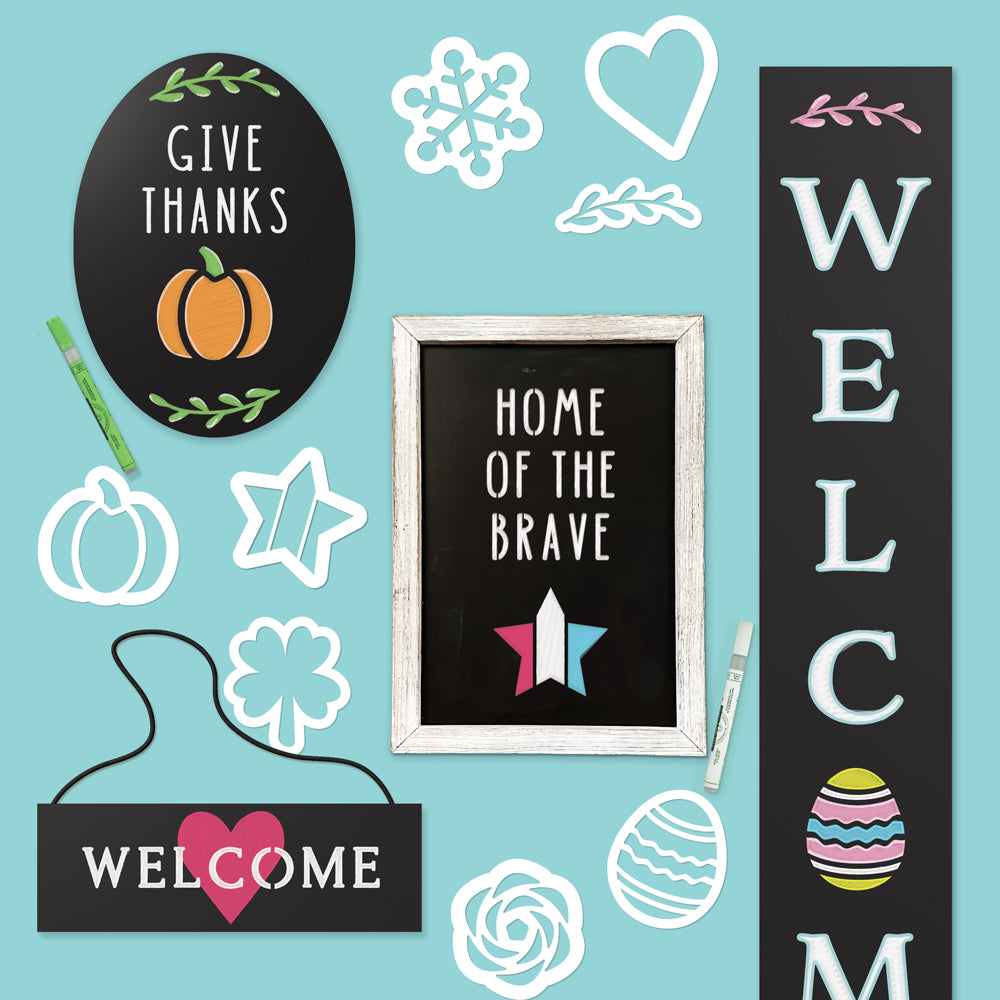 Collection of chalkboards including large outdoor chalkboard, oval frameless chalkboard, framed chalkboard and hanging chalkboard each creatively decorated with magnetic Holiday Chalkboard Stencil Set, featuring themes like 'GIVE THANKS,' 'HOME OF THE BRAVE,' ‘WELCOME’ and seasonal designs.